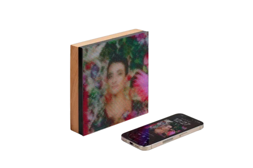 Tuneshine LED album art display in a wooden frame, next to an iPhone